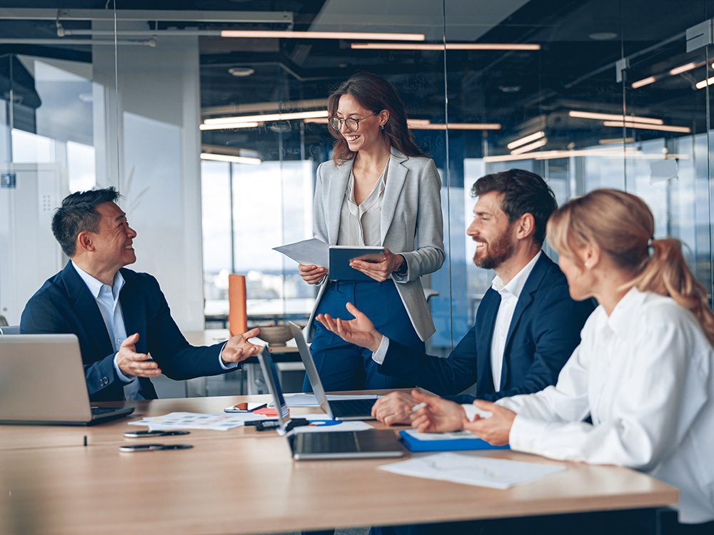 Group of professionals meeting at a conference table discussing documents and ideas