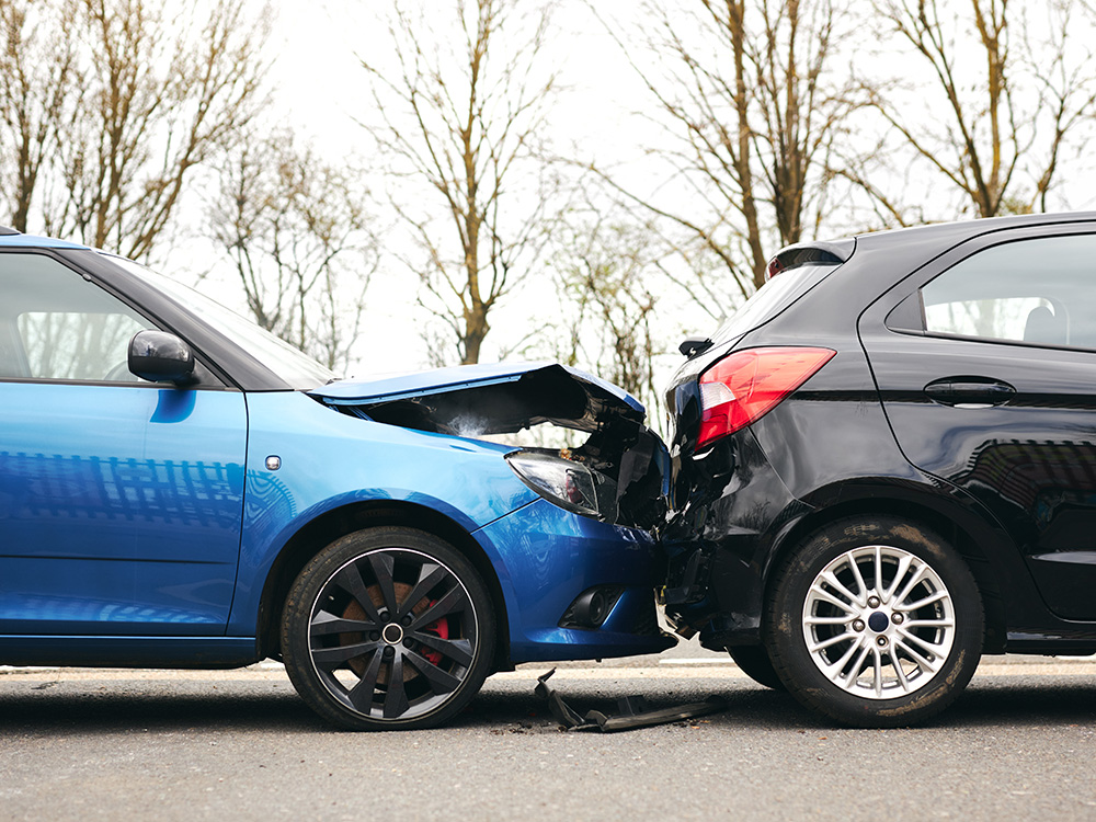 Two cars involved in a rear-end collision with visible damage to both vehicles