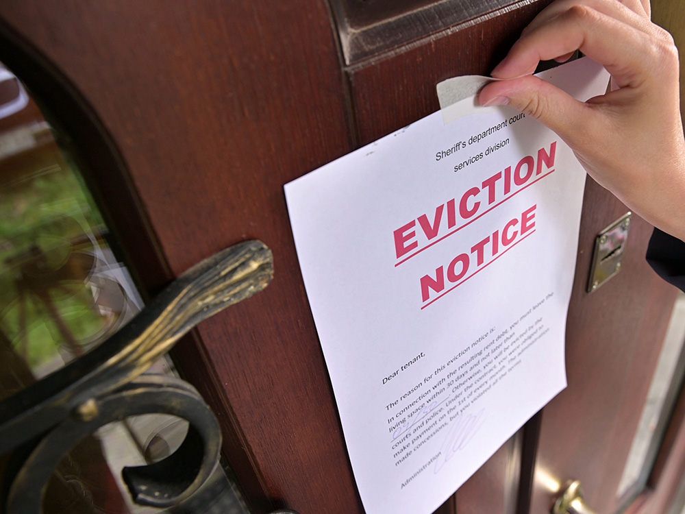 Hand posting an eviction notice on a residential front door